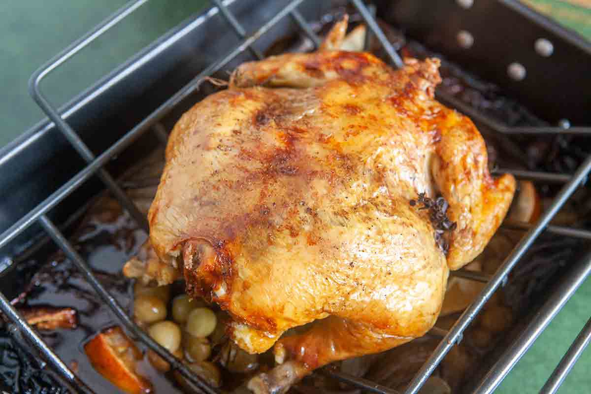 roast chicken with grapes in roasting pan