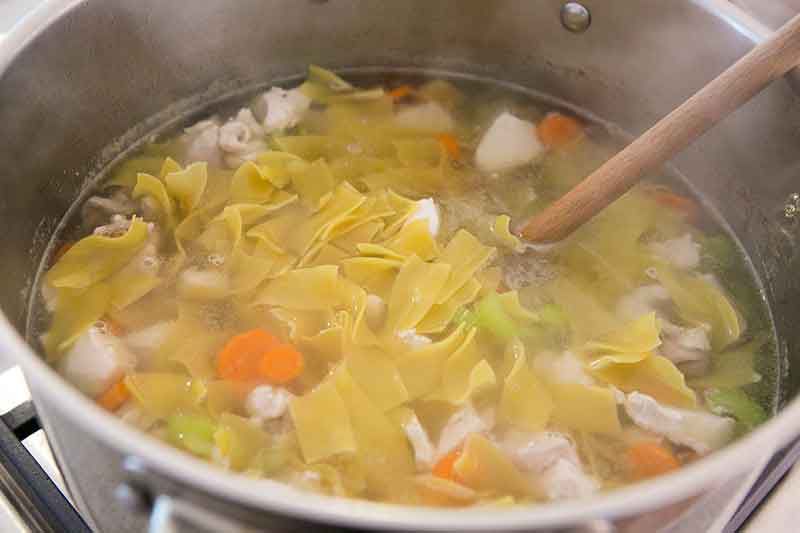 Egg noodles mixed into a homemade chicken soup.