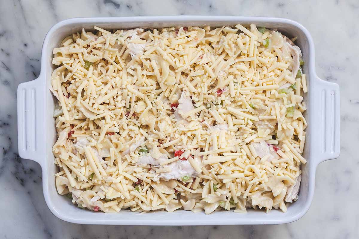 Uncooked Creamy Chicken Noodle Casserole in a white baking dish.