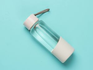 Bottle of water for sports and outdoor activities on blue background. Top view