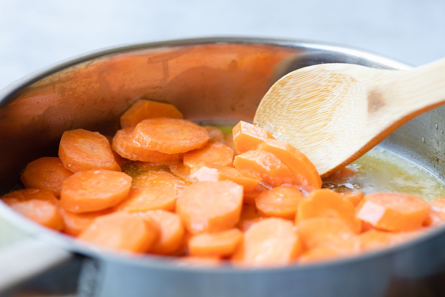 Sauteeing carrots in a skillet to make a glazed carrots recipe.