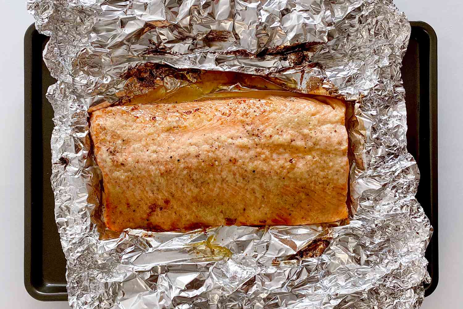 Salmon out of the oven and broiled as it rests on a baking sheet