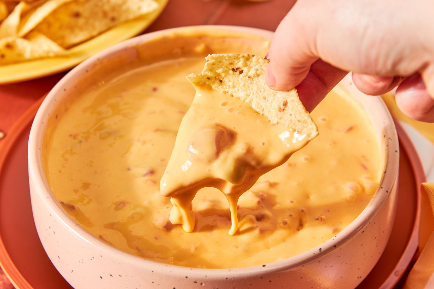 someone dipping a chil in a bow of 2-ingredient ro*tel dip