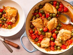 Overhead view of a blue dutch oven and small white bowl of tuscan-style chicken thighs recipe