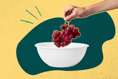 hand placing grapes in a bowl 