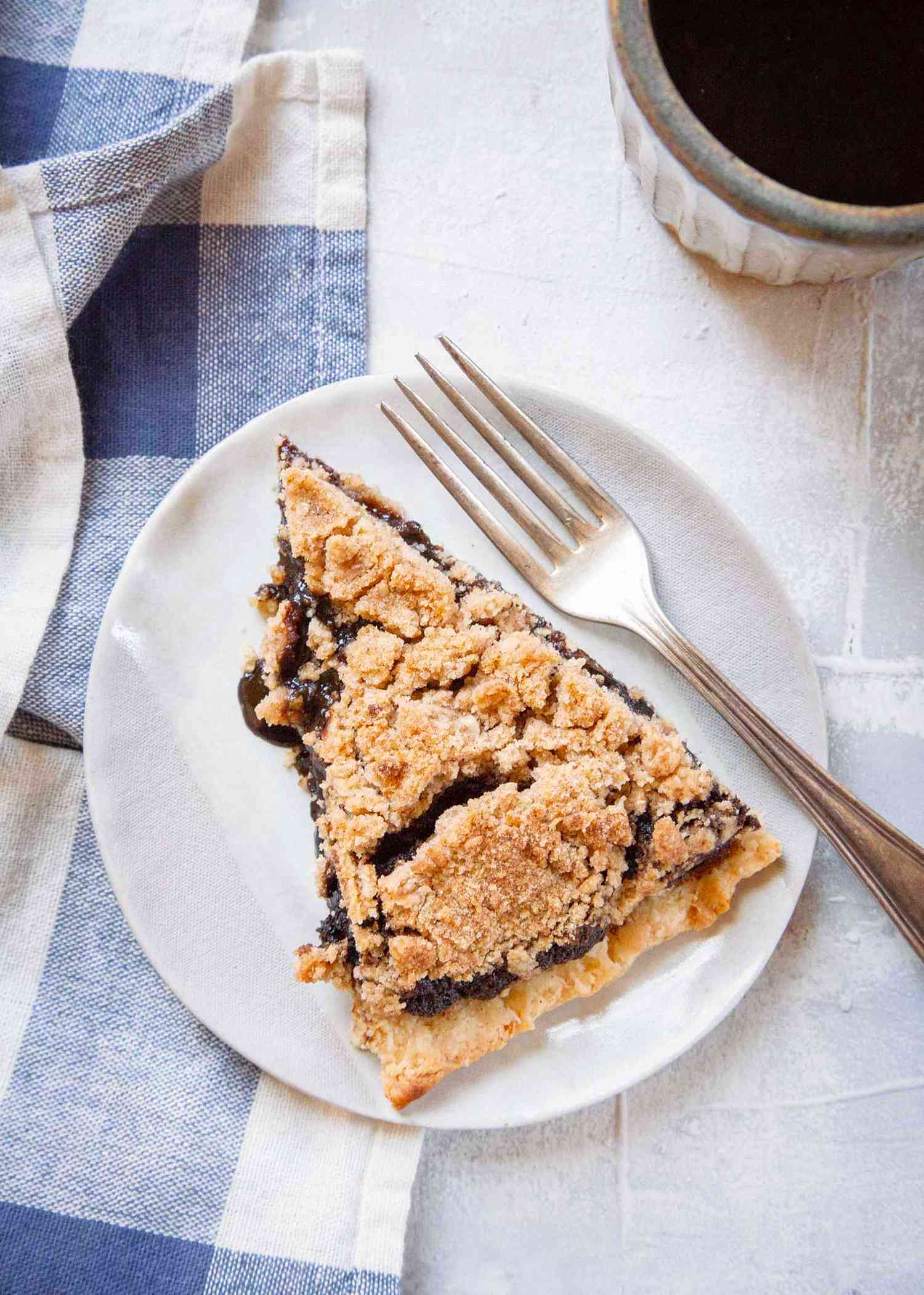 Shoo-fly pie on a white plate with a fork next to it.