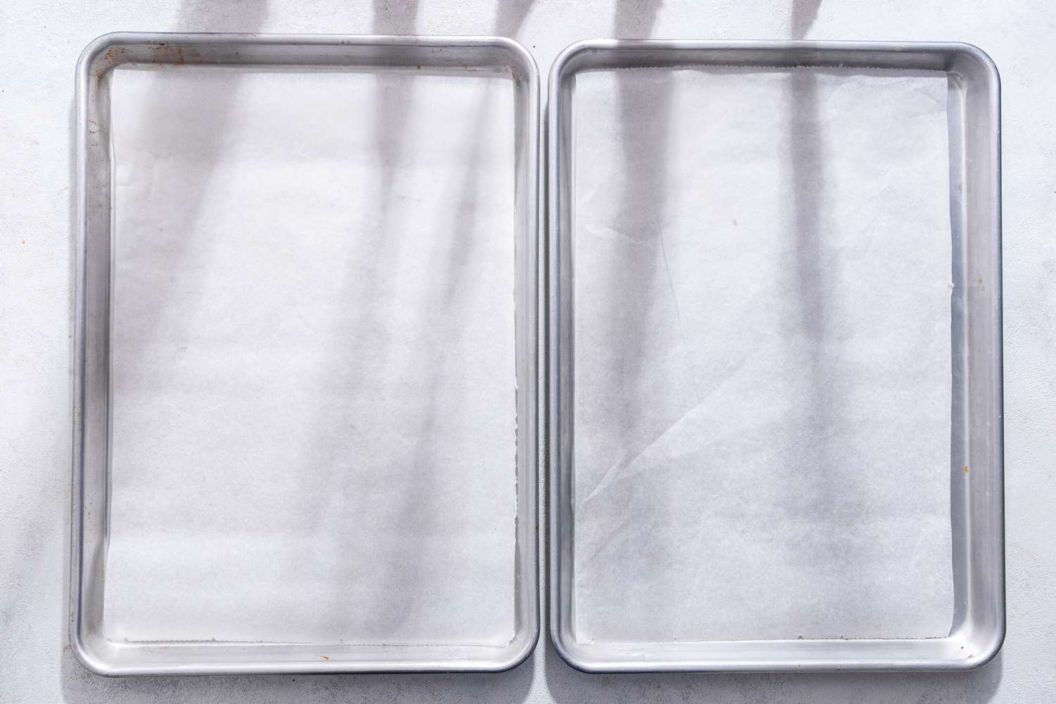 Two baking trays lined with parchment paper for monster cookie recipe