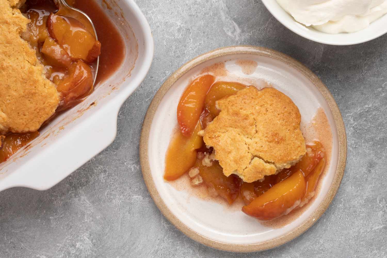 fresh peach cobbler and a bowl of whipped cream