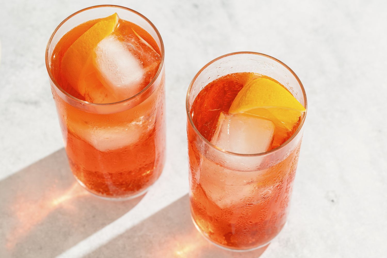 Two glasses of cocktails with ice and citrus slices