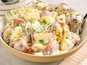 A bowl of potato salad with herbs and dressing