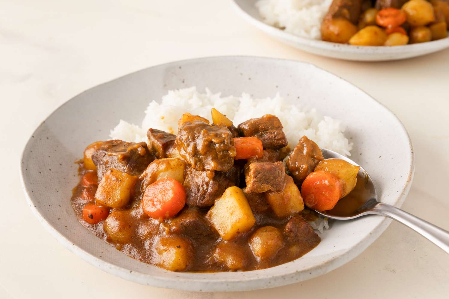 A serving of Korean curry rice with chunks of vegetables and meat