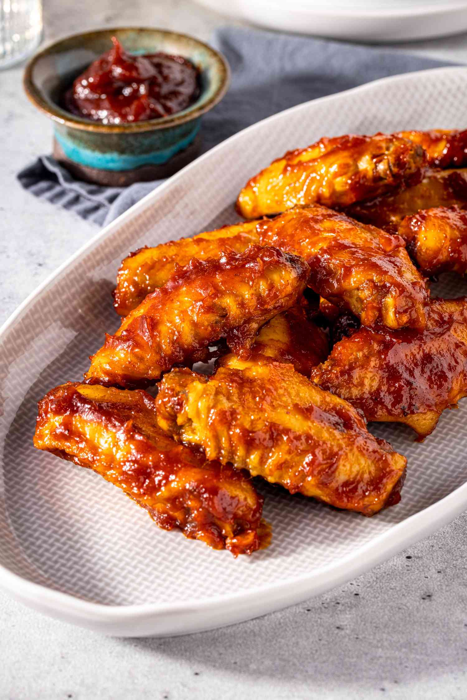 Platter of Microwave BBQ Chicken Wings with a Bowl of BBQ Sauce Next to It