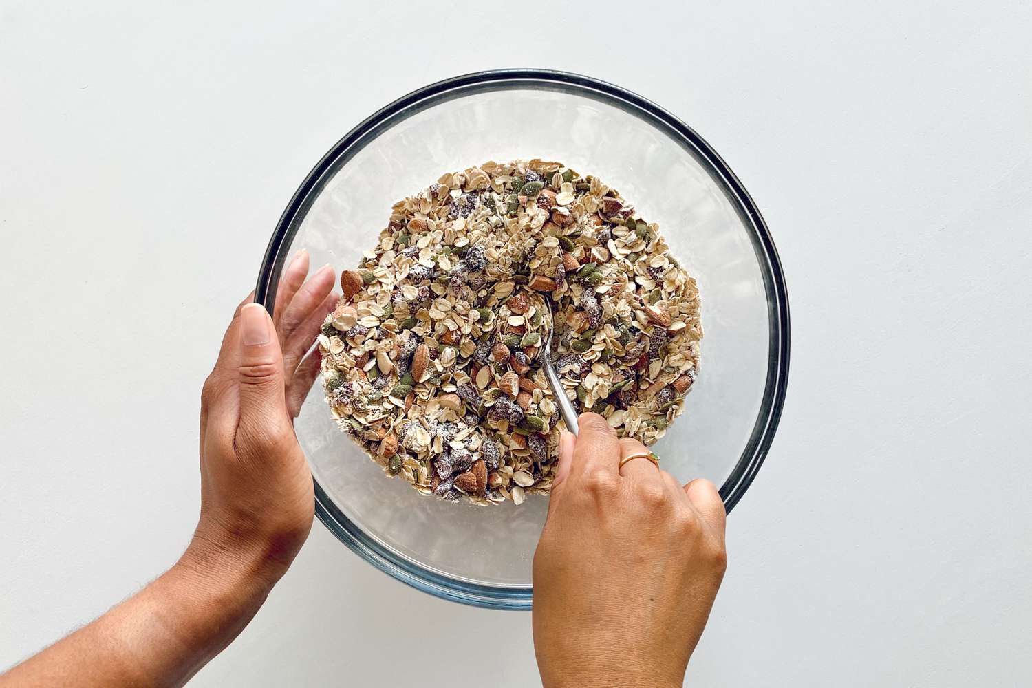 Mixing nuts and seeds into dry ingredients for Chewy Granola Bars with Almonds, Dried Cherries, Pumpkin Seeds and Coconut Flakes.