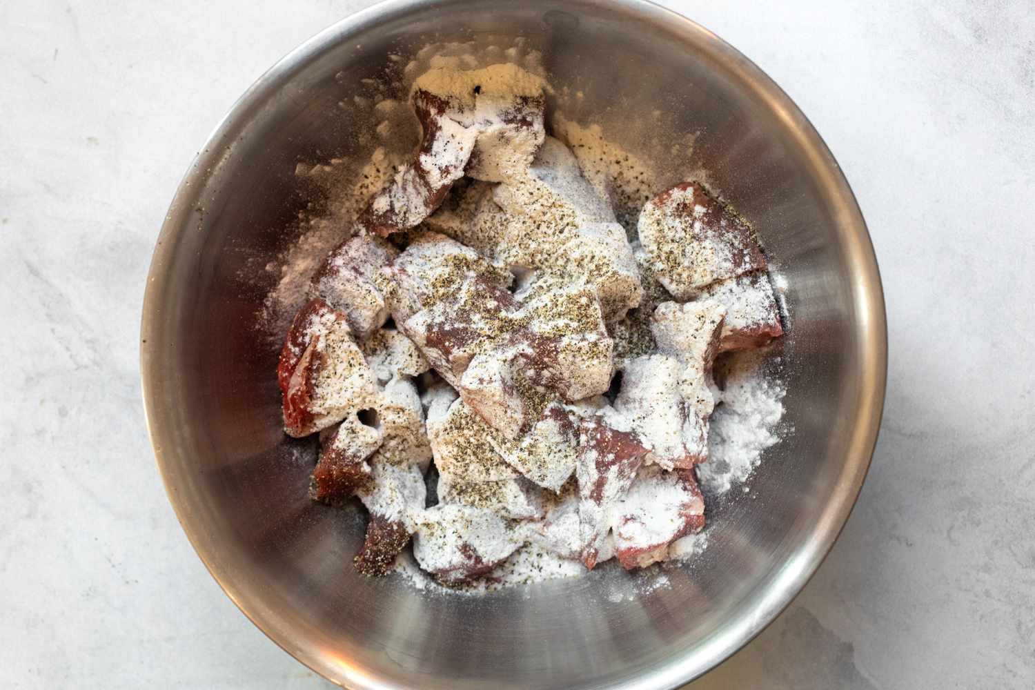 Bowl of Beef with Flour, Salt, and Black Pepper for Slow Cooker Beef Stew Recipe