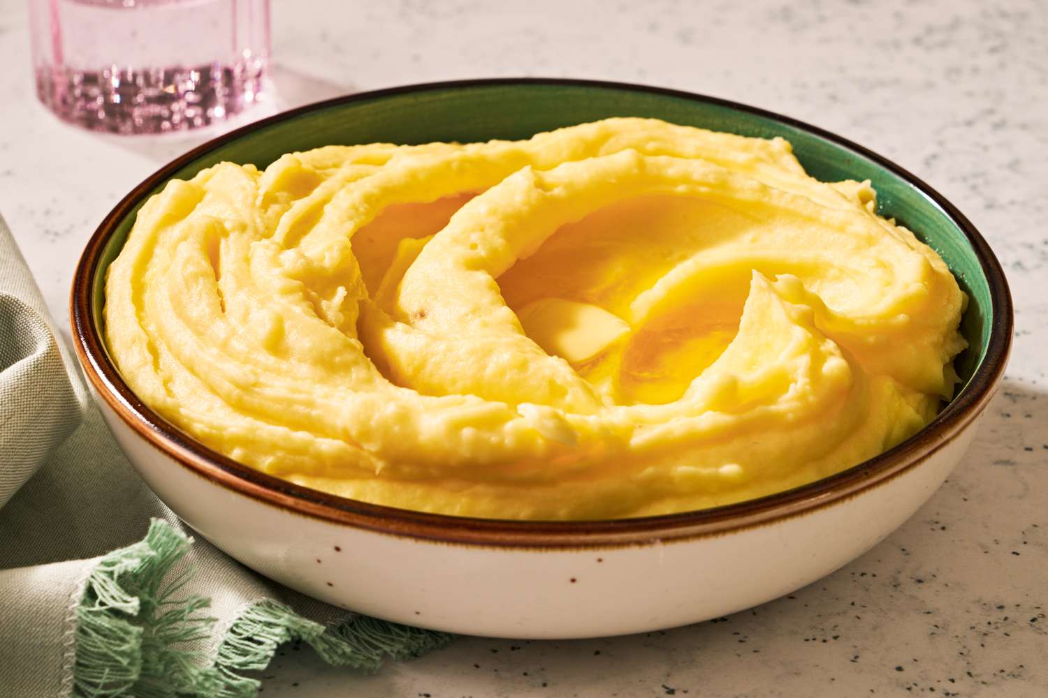 A bowl of mashed potatoes with butter melting on top of it