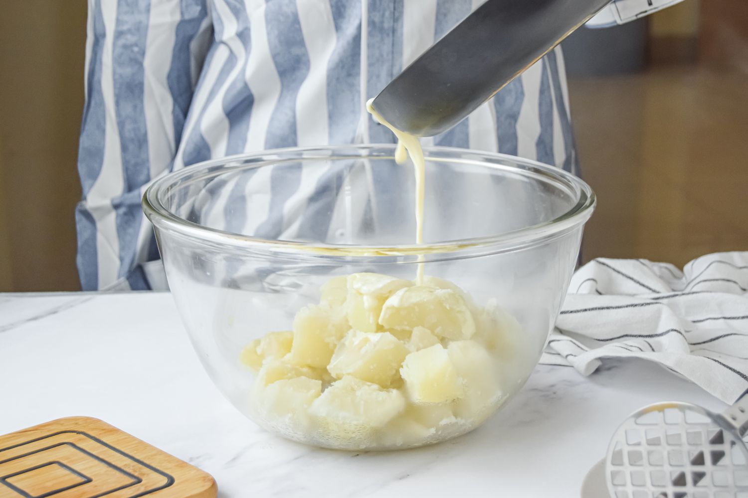 Cream and Butter Mix Added to Bowl of Cooked Potatoes for Perfect Mashed Potatoes Recipe