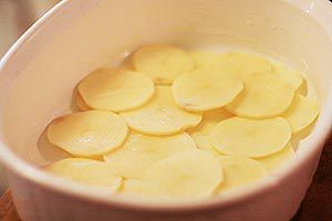 sliced potatoes in baking dish for scalloped potatoes
