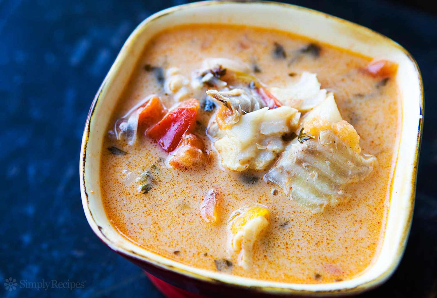 A bowl of seafood stew in a creamy broth with vegetables