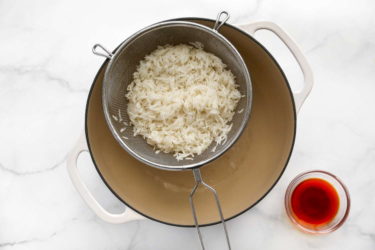 Colander of Rice Set on the Empty Dutch Oven Next to the Bowl of Saffron