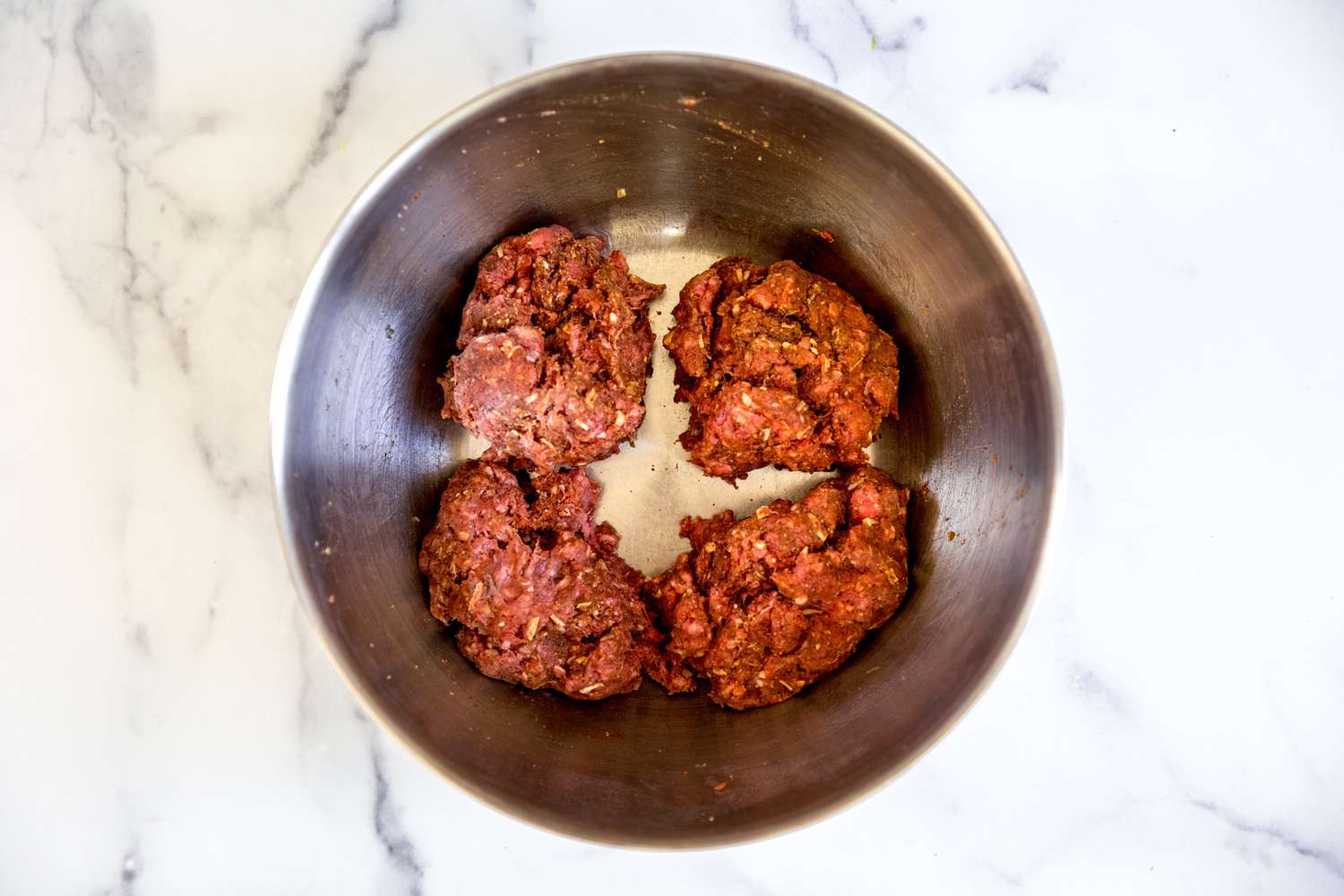 Mini meatloaves shaped in a bowl.
