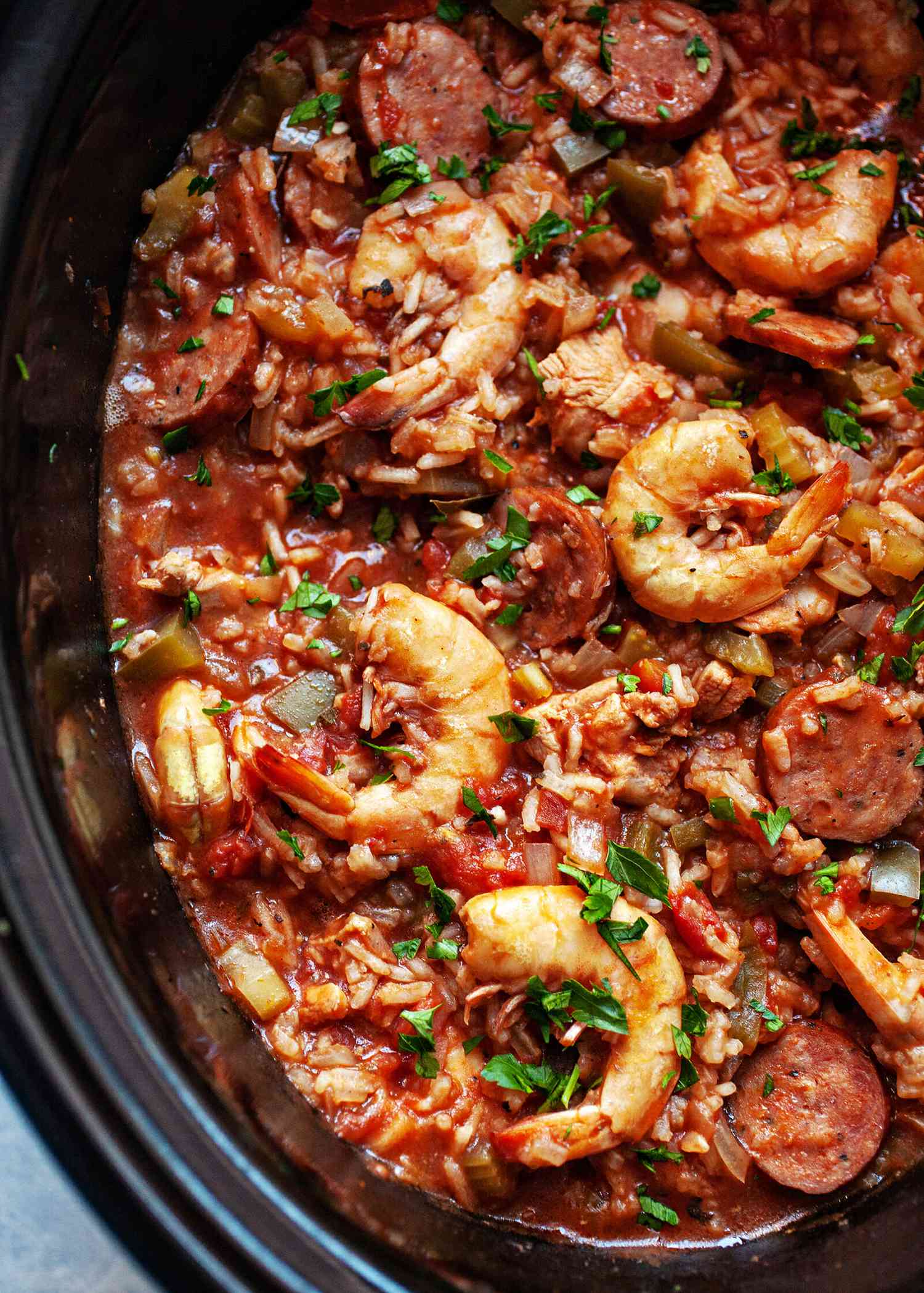 A close up of a slow cooker filled with jambalaya