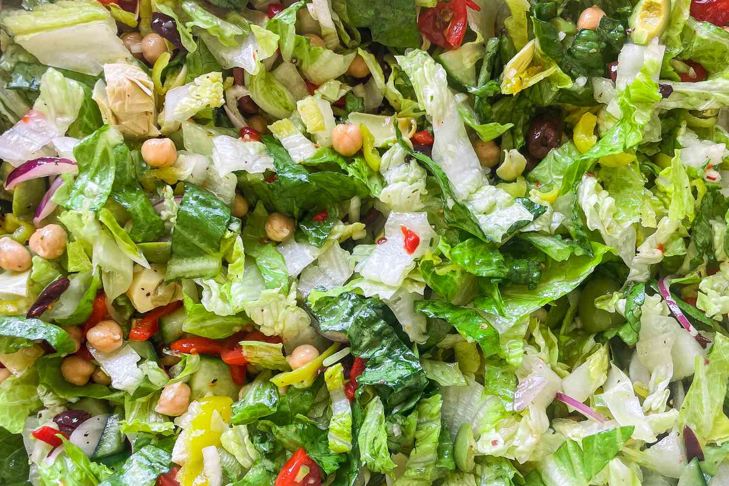 Perfect salad for pizza close-up with lettuce, chickpeas, olives, and peppers