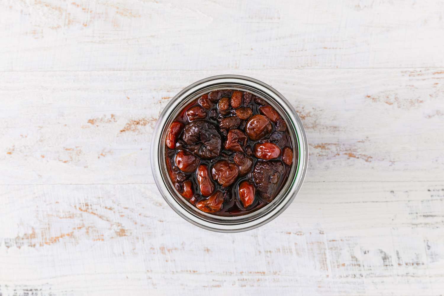 overhead view of dried fruit soaking in rum mixture for Jamaican Black Cake