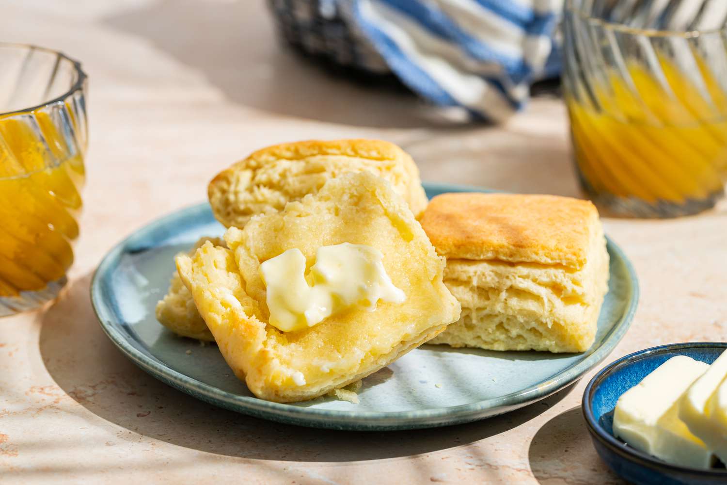 Closeup view of a small plate of Mayonnaise Biscuits with one cut open and buttered