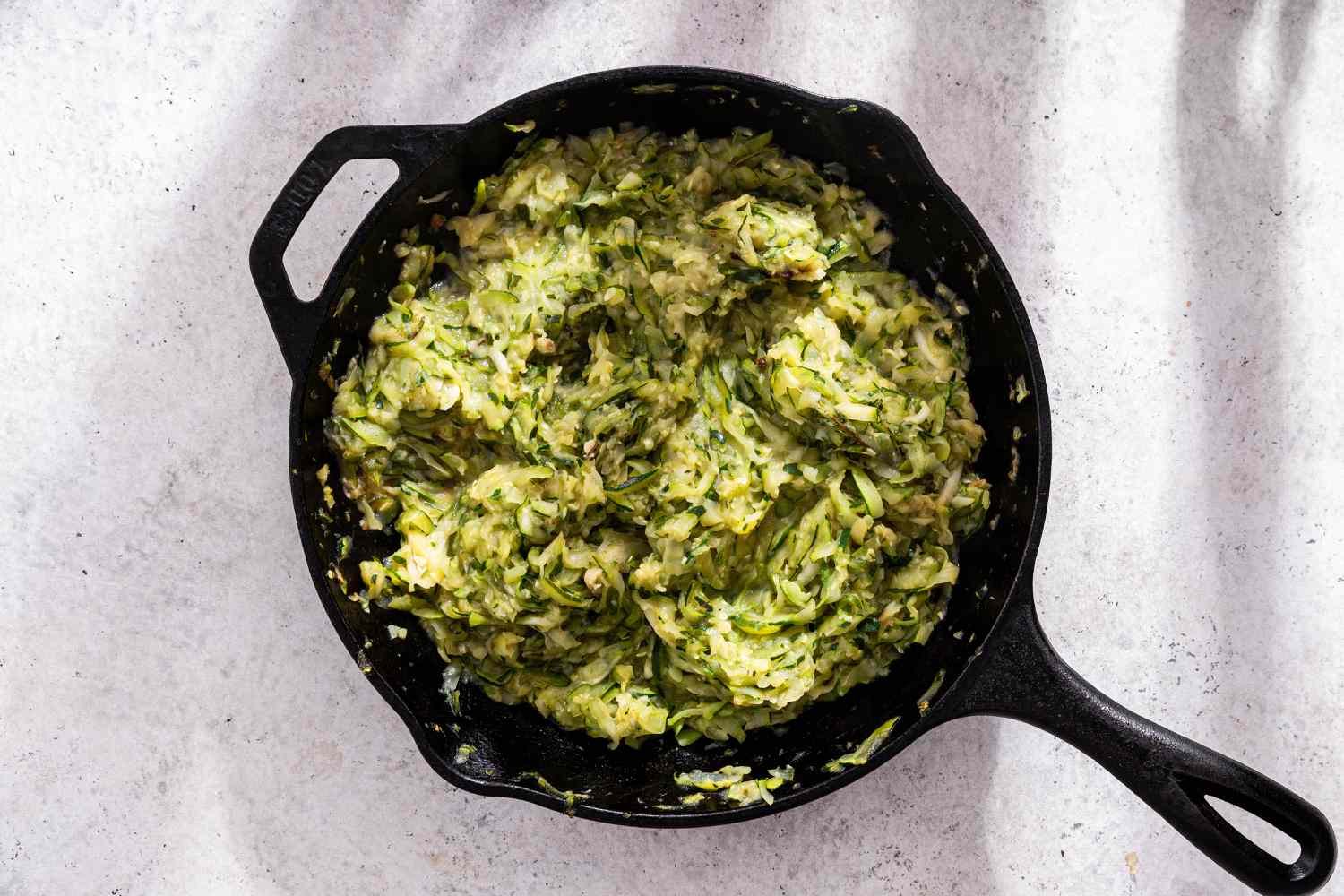 Shredded Zucchini Reduced in a Cast Iron Skillet