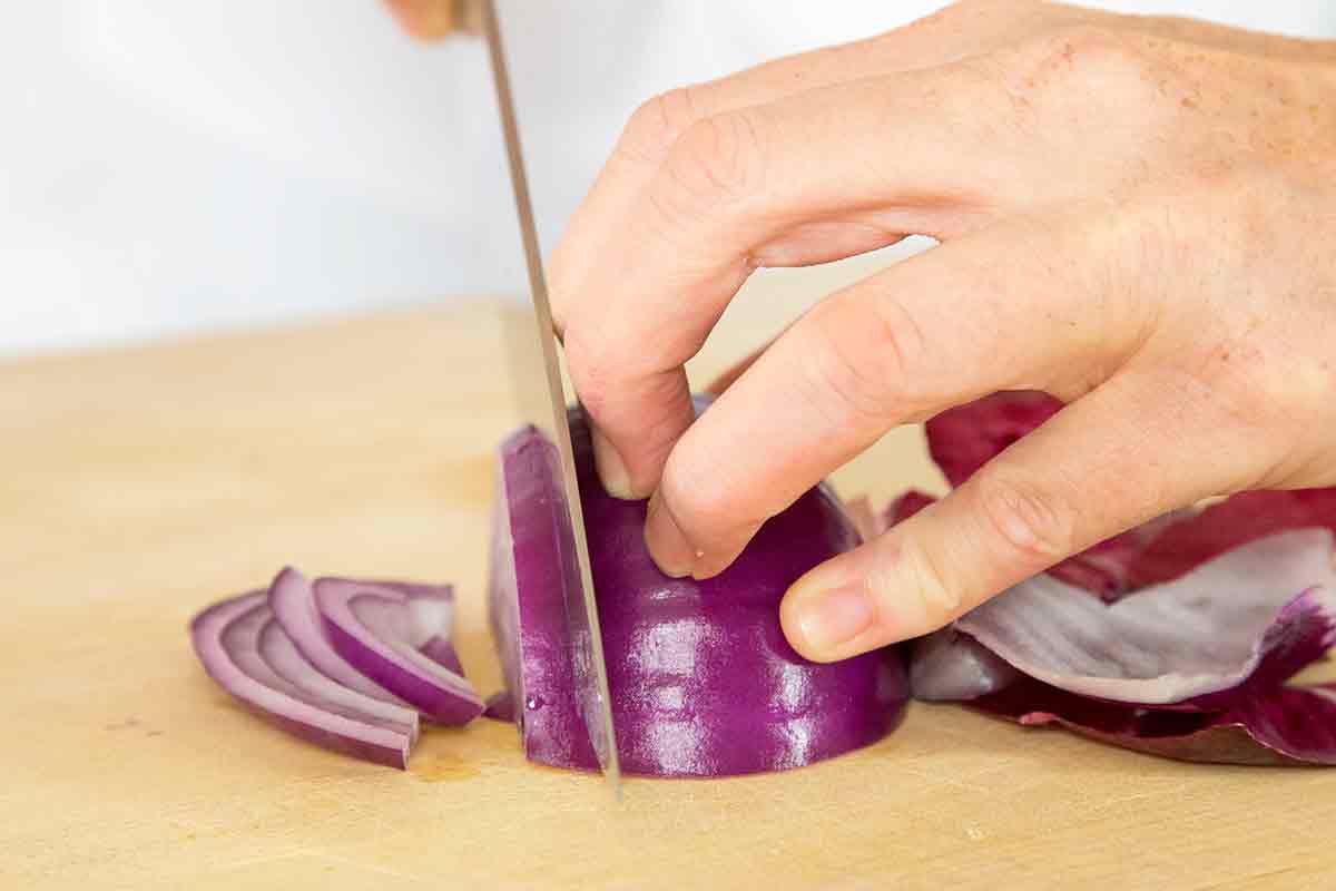 curl your fingers and use your knuckles as a guide for the knife