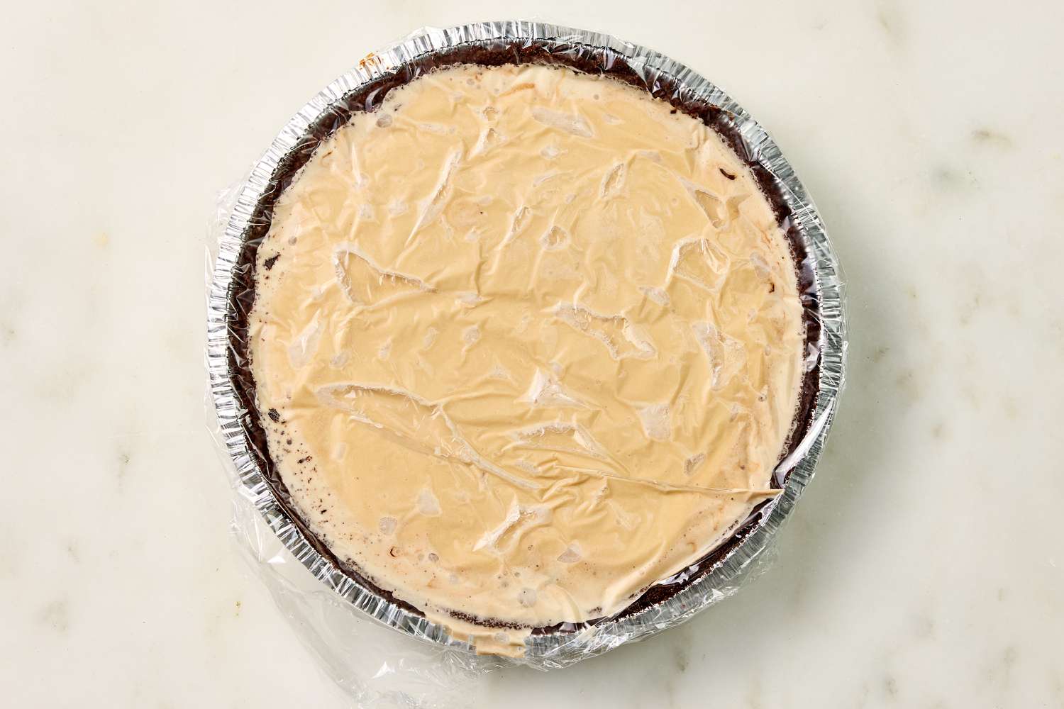 overhead view of Easy Bushwacker Pie, covered with plastic wrap