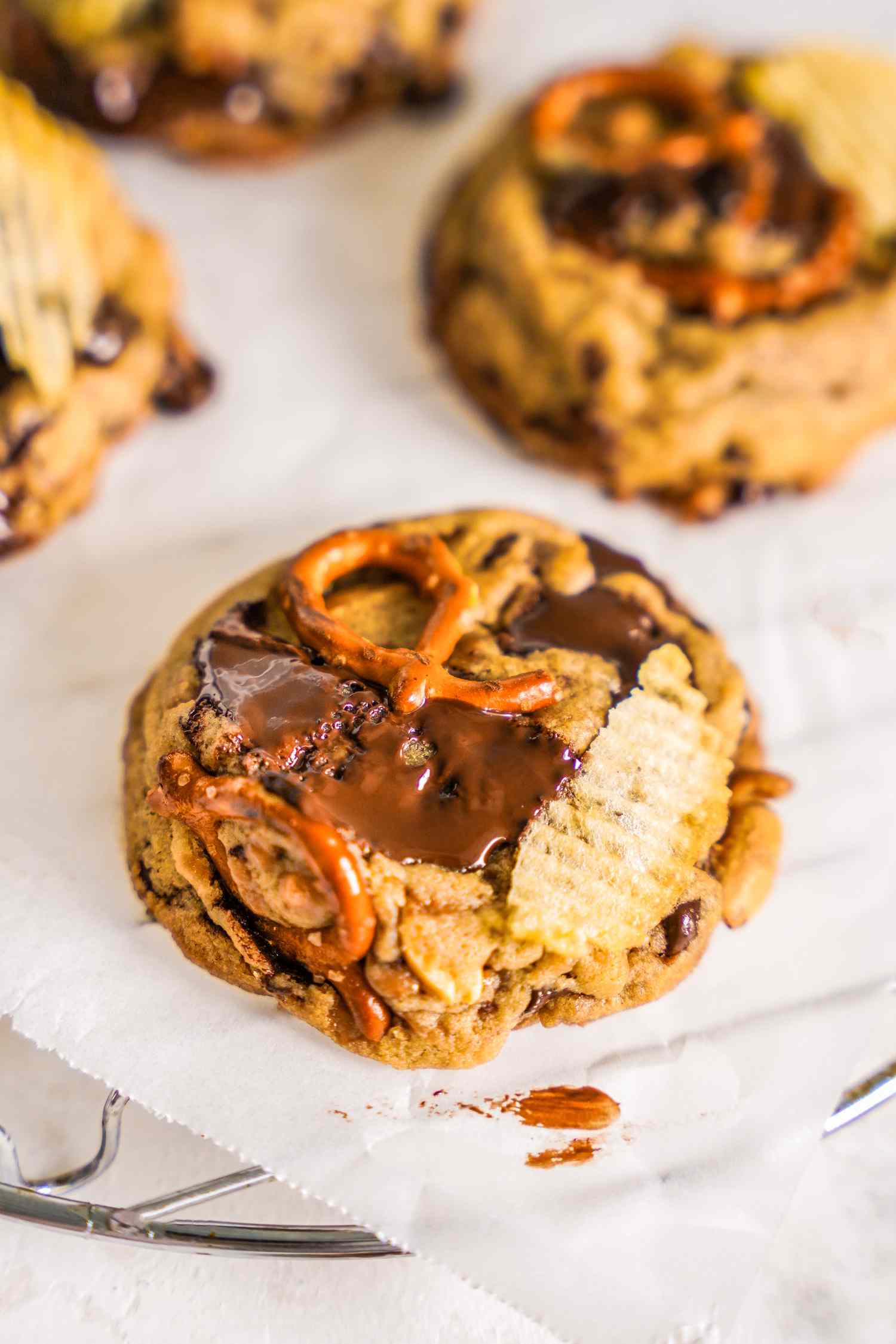 Kitchen Sink Cookies on a Piece of Crumpled Parchment Paper on a Cooling Rack