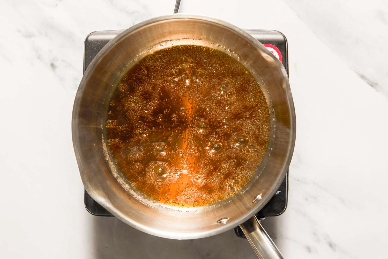 Sugar syrup turning into caramel in a pot for flan recipe