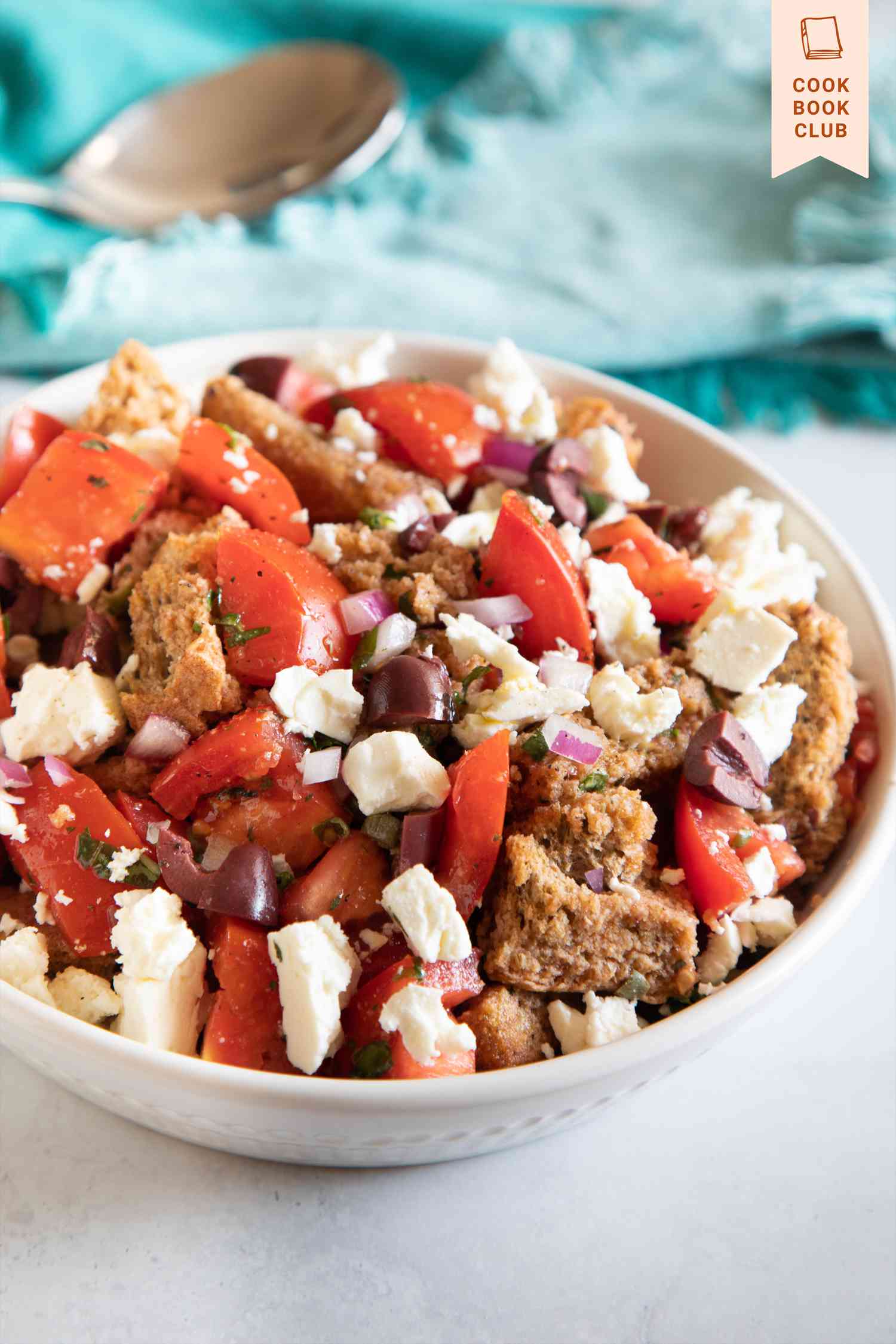 Authentic Cretan salad in a bowl with a teal linen behind ti.