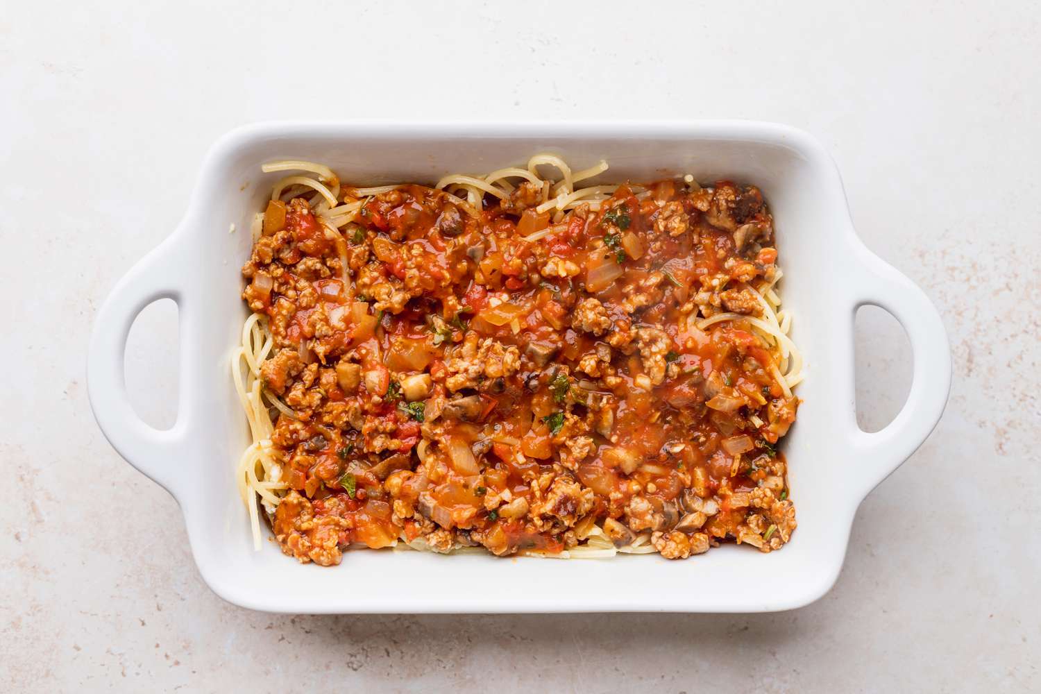 Baked spaghetti in a dish ready to bake