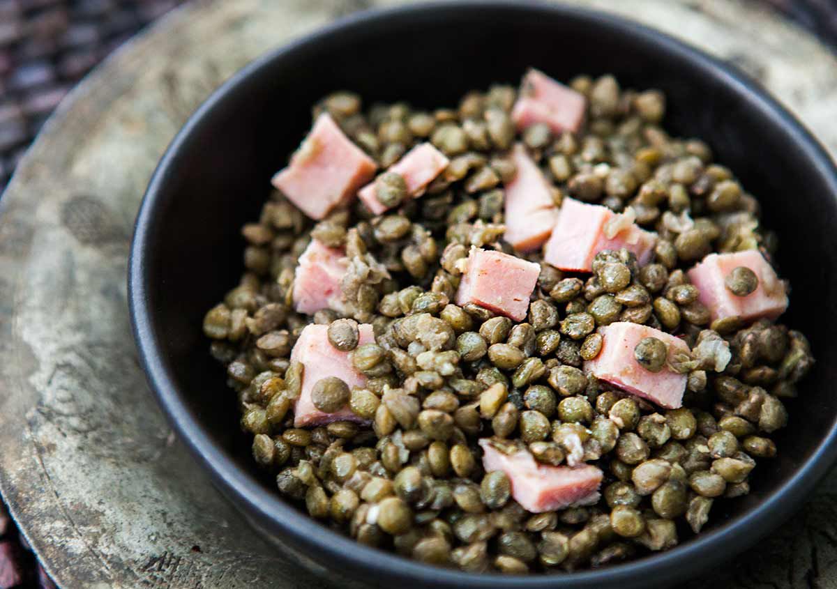 lentils and ham in a dark gray bowl