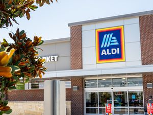 A view of the storefront of an Aldi supermarket, showing signs and the entrance