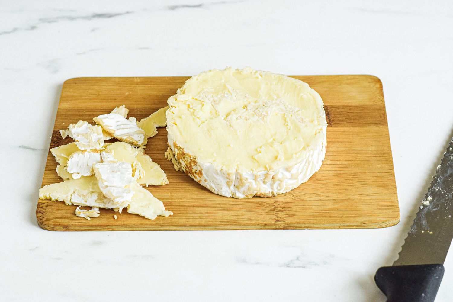 Cutting the rind off the top of brie cheese.