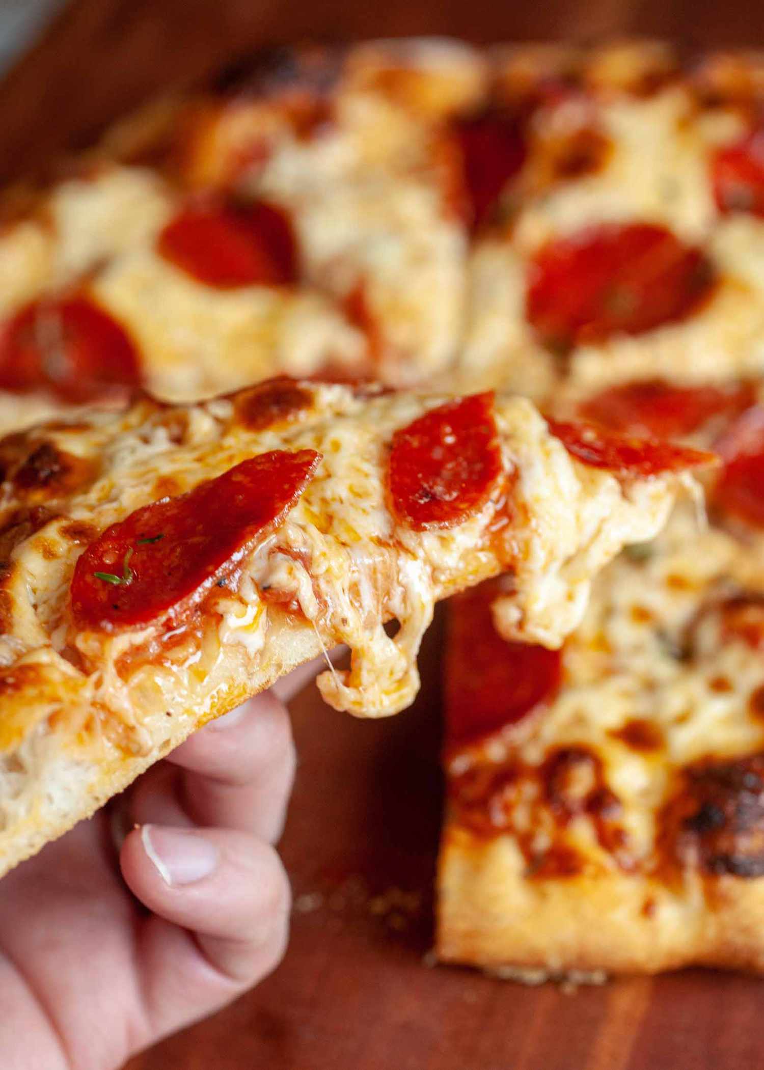 A slice of gooey cheese from homemade pepperoni pizza recipe