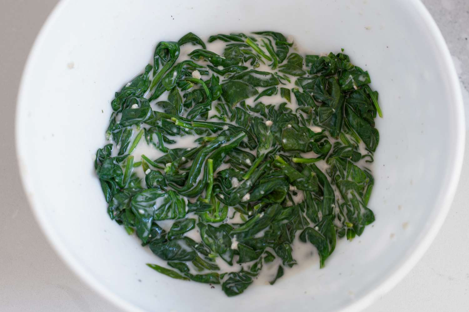 coconut cream in wilted spinach