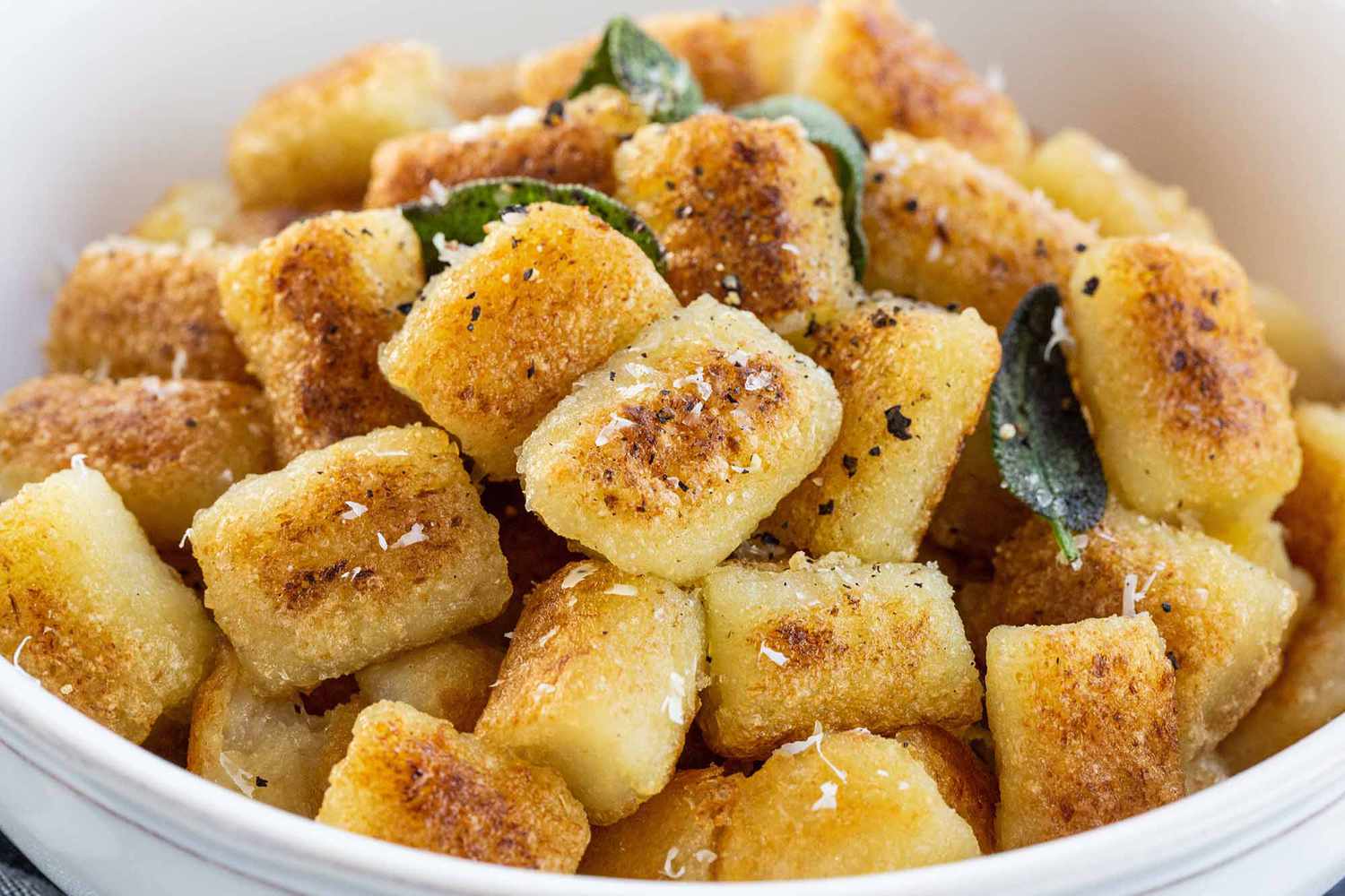 cauliflower gnocchi with sageleaves in a white bowl