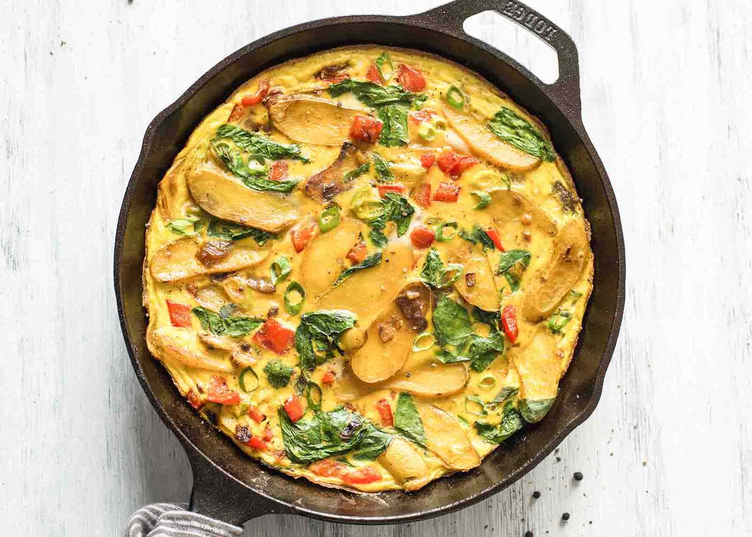 A top down photo of a cast iron skillet with potato frittata inside.