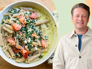 Jamie Oliver next to a bowl of pasta with smoked salmon and greens