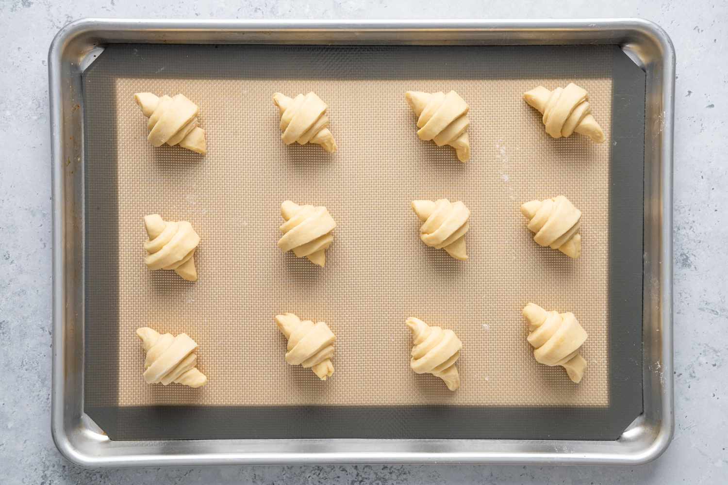 Homemade Crescent Rolls Proofing on a Lined Baking Pan