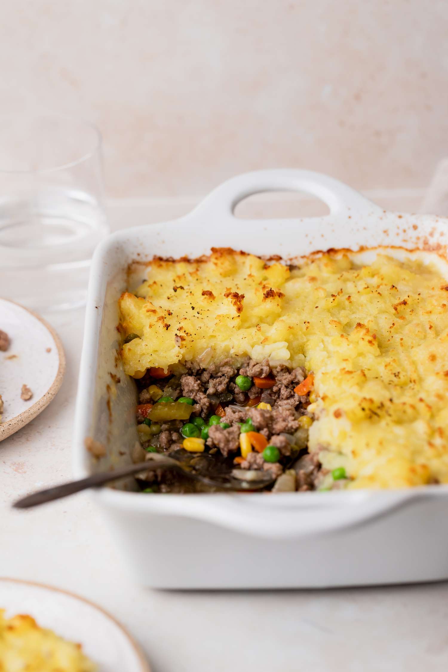 A casserole dish with a piece of shepherd's pie removed.