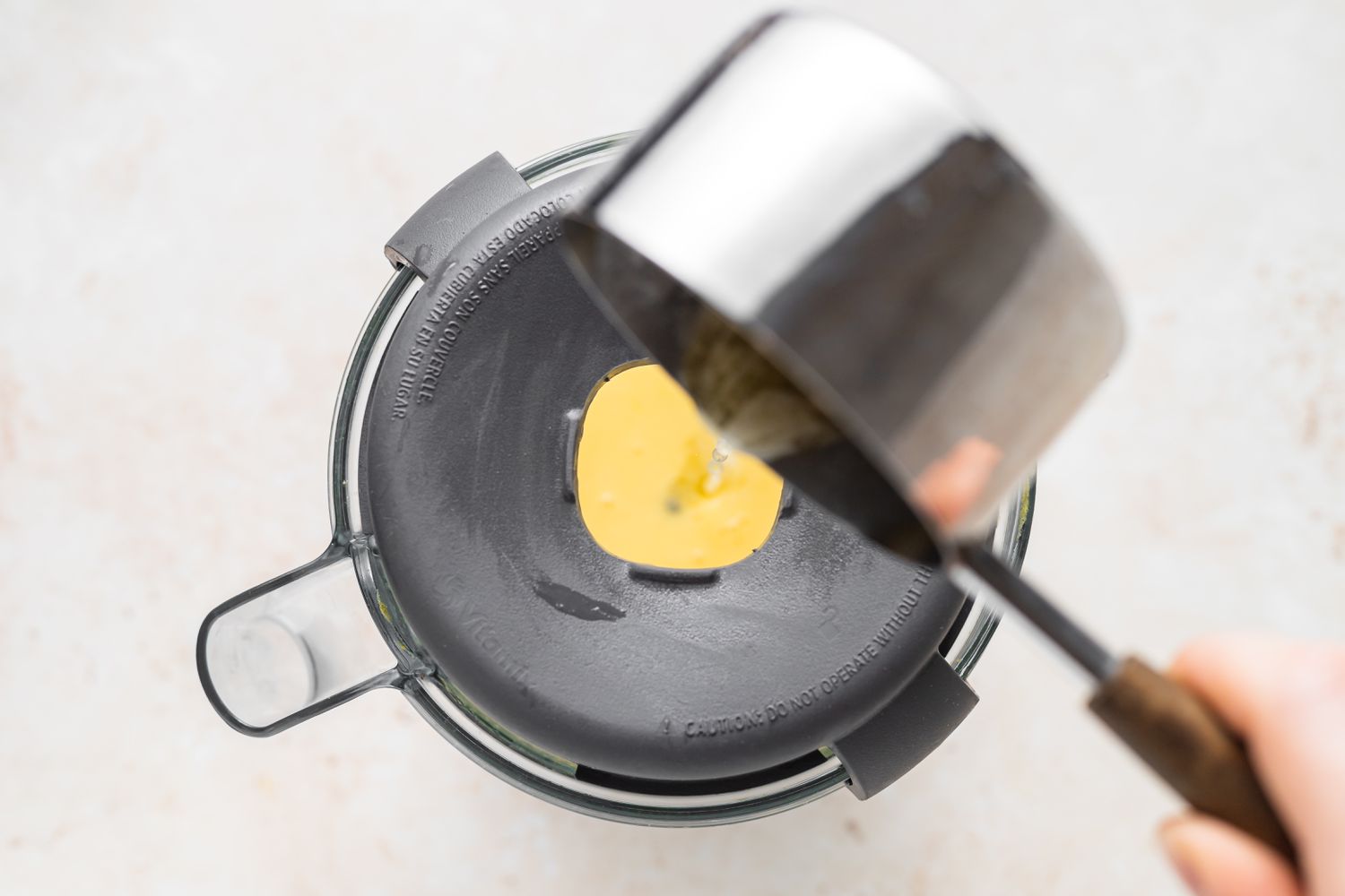 Drizzling melted butter in Blender Hollandaise Sauce.