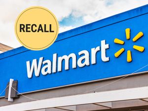 Walmart logo on storefront with a circular recall symbol in the corner