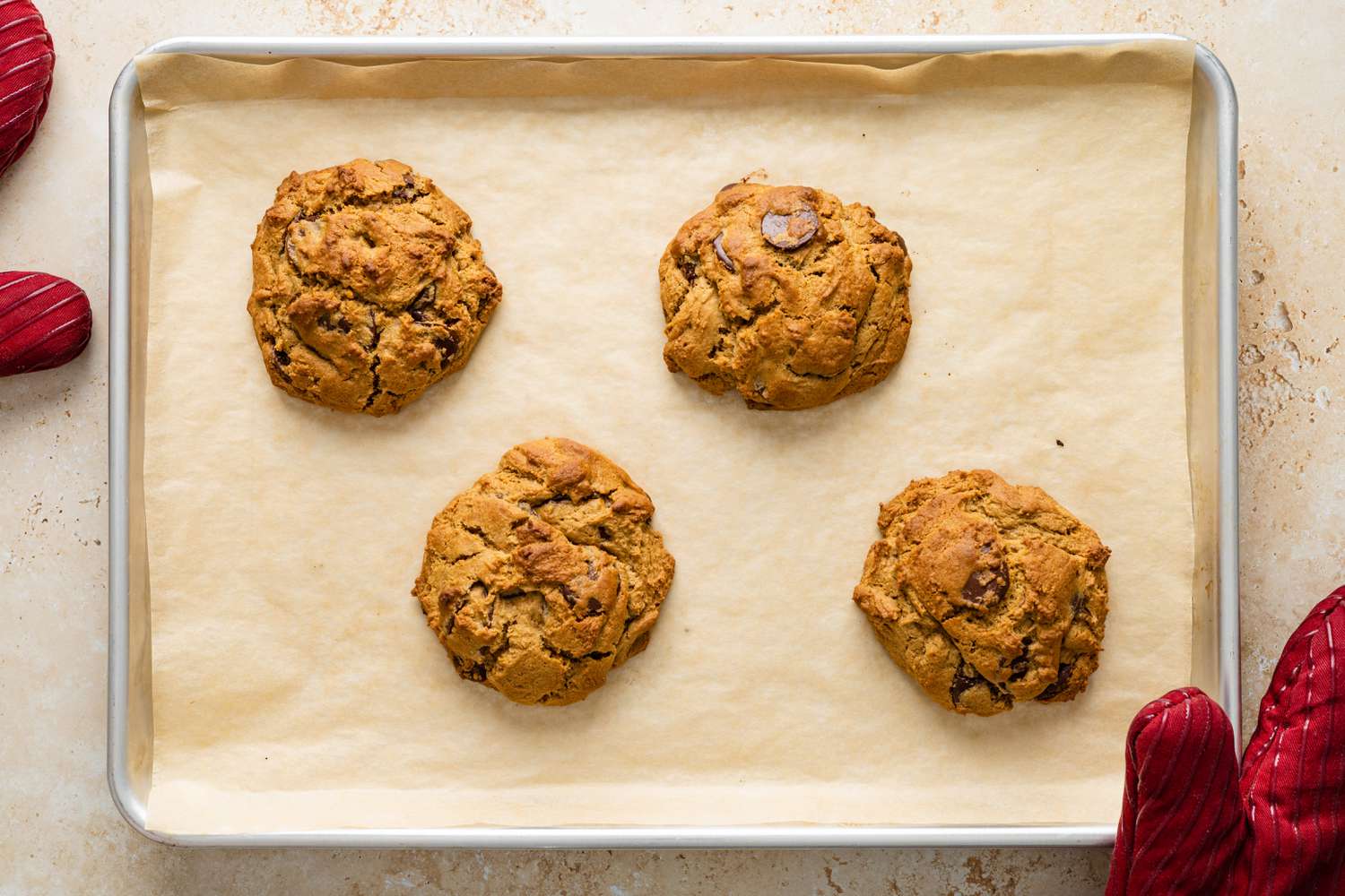 Four big chocolate chip cookies baked on Nordic Ware sheet pan