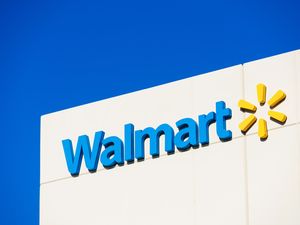 The Walmart logo on a building against a blue sky