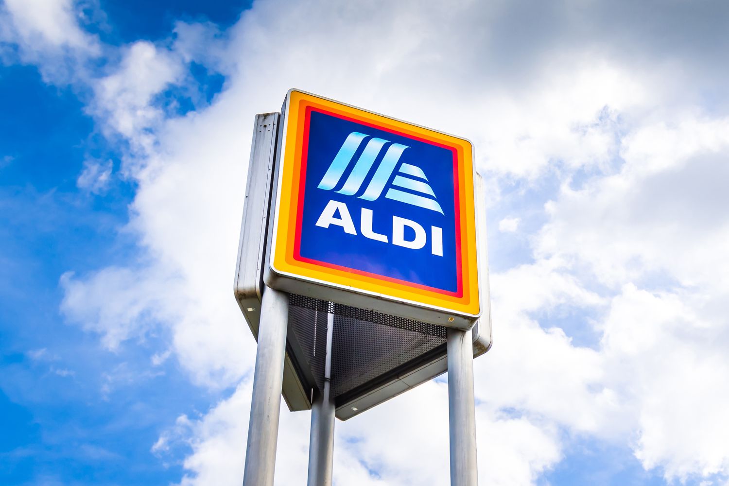 Signpole displaying Aldi logo against a cloudy sky